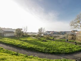 A view of the grass and trees with houses and a bridge at Island House Aberaeron