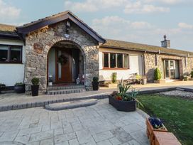 An entrance area with a stone wall and pathway at Brookway Lodge Caerwys