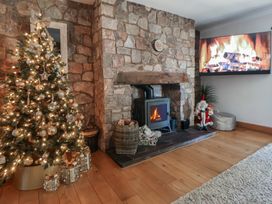 A living room with a Christmas tree and a fireplace at Brookway Lodge in Caerwys