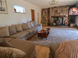 A living room with a fireplace and a Christmas tree at Brookway Lodge in Caerwys