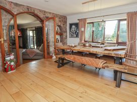A dining room with a wooden table and benches at Brookway Lodge in Caerwys
