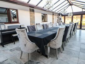 A dining area with a large table and chairs at Brookway Lodge Caerwys
