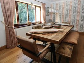 A dining room with a wooden table and chairs at Brookway Lodge in Caerwys