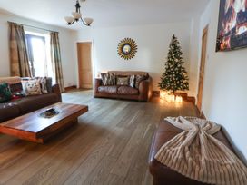 A living room with a Christmas tree and brown furniture at Brookway Lodge in Caerwys
