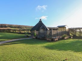 A garden with a hut and deck at Brookway Lodge in Caerwys