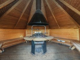 A circular table with a fireplace in a wooden room at Brookway Lodge Caerwys