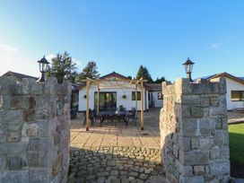 An outdoor area with a gazebo and furniture at Brookway Lodge in Caerwys
