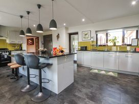 A kitchen with a kitchen island and stools at Brookway Lodge in Caerwys