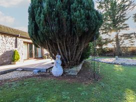 A garden with a snowman and a large tree at Brookway Lodge, Caerwys