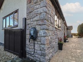 An outdoor area with a stone wall and an electric vehicle charger at Brookway Lodge Caerwys