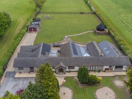 An aerial view of a house with a garden and playground at Brookway Lodge, Caerwys