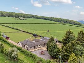An outdoor view of a house and field at Brookway Lodge in Caerwys