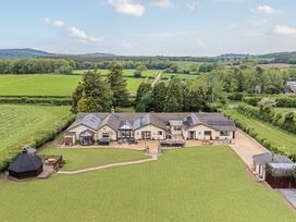 A garden with a house and patio area at Brookway Lodge in Caerwys