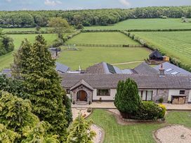 An outdoor view of a house with a garden and playground at Brookway Lodge Caerwys