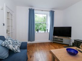 A living room with a sofa, television, and window at Ty Capel Bethania in Nant Gwynant