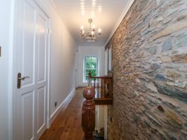 A hallway with a stone wall and wooden railing at Ty Capel Bethania Nant Gwynant
