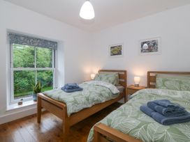 A bedroom with two beds and a window at Ty Capel Bethania Nant Gwynant