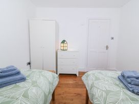 A bedroom with two beds, a wardrobe, and a chest of drawers at Ty Capel Bethania in Nant Gwynant