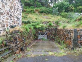 An outdoor area with a gate and stone walls at Ty Capel Bethania Nant Gwynant
