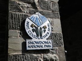 A sign for Snowdonia National Park on a stone wall