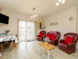 A living room with a sofa and dining area at Duffy Lodge Kilmacloo near Creeslough County Donegal