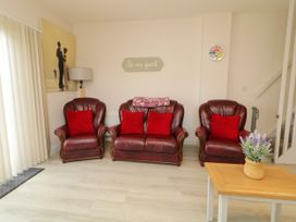 A living room with sofas and a table at Duffy Lodge in Kilmacloo near Creeslough, County Donegal