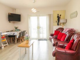 A living room with sofa and television at Duffy Lodge, Kilmacloo near Creeslough, County Donegal