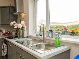 A kitchen with a sink and flowers on the countertop at Duffy Lodge Kilmacloo near Creeslough, County Donegal