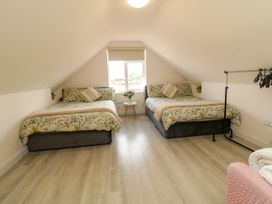 A bedroom with two beds and a small table with flowers at Duffy Lodge Kilmacloo near Creeslough, County Donegal
