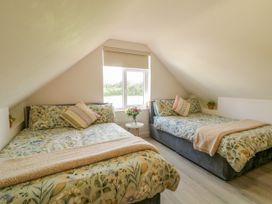 A bedroom with two beds and a window at Duffy Lodge, Kilmacloo near Creeslough, County Donegal