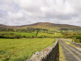 A field with a road leading towards a mountain at Duffy Lodge in Kilmacloo near Creeslough, County Donegal