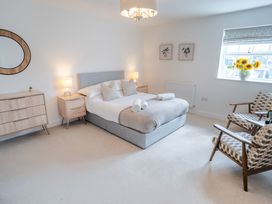 A bedroom with a bed and two chairs at Ullswater in Ulverston