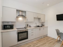 A kitchen with cabinets, appliances, and a dining table at Ullswater in Ulverston