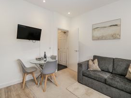 A living room with a sofa and dining area at Ullswater in Ulverston