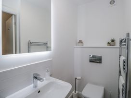A bathroom featuring a sink, toilet, and a mirror at Ullswater in Ulverston