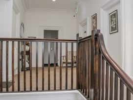 A hallway with a staircase and a chair at Ullswater in Ulverston