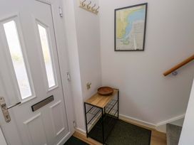 A hallway with a front door and a console table at No.22 The Clicketts in Tenby