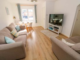 A living room with a sofa and dining table at No.22 The Clicketts Tenby