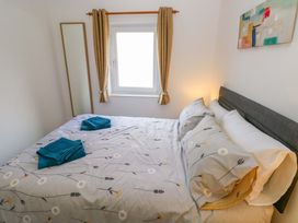 A bedroom with a bed and a mirror at No.22 The Clicketts in Tenby