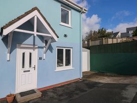 An exterior view of a house with a blue wall and a front door at No.22 The Clicketts in Tenby