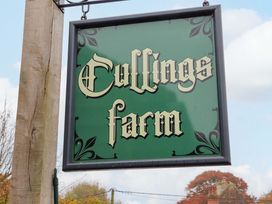 A green sign with old style font saying Cullings farm outdoors