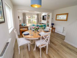 A dining room with a table set for meals and a couch at Lavender Cottage Beadnell