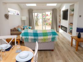 A living room with a sofa and dining table at Lavender Cottage in Beadnell