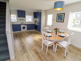 A dining room with a round table and chairs at Lavender Cottage in Beadnell