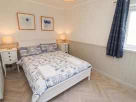 A bedroom with a bed and bedside tables at Lavender Cottage Beadnell