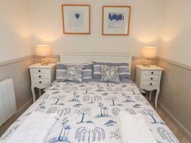 A bedroom with a bed and furniture at Lavender Cottage Beadnell