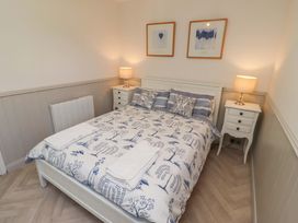 A bedroom with a bed and bedside tables at Lavender Cottage Beadnell