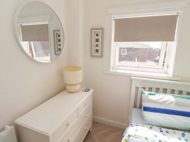 A bedroom with a mirror and lamp at Lavender Cottage in Beadnell