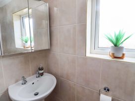 A bathroom with a sink and mirror at Lavender Cottage Beadnell