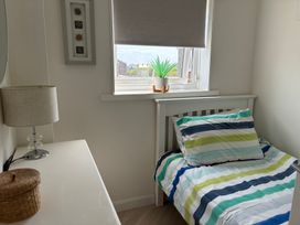 A bedroom with a bed and lamp at Lavender Cottage Beadnell